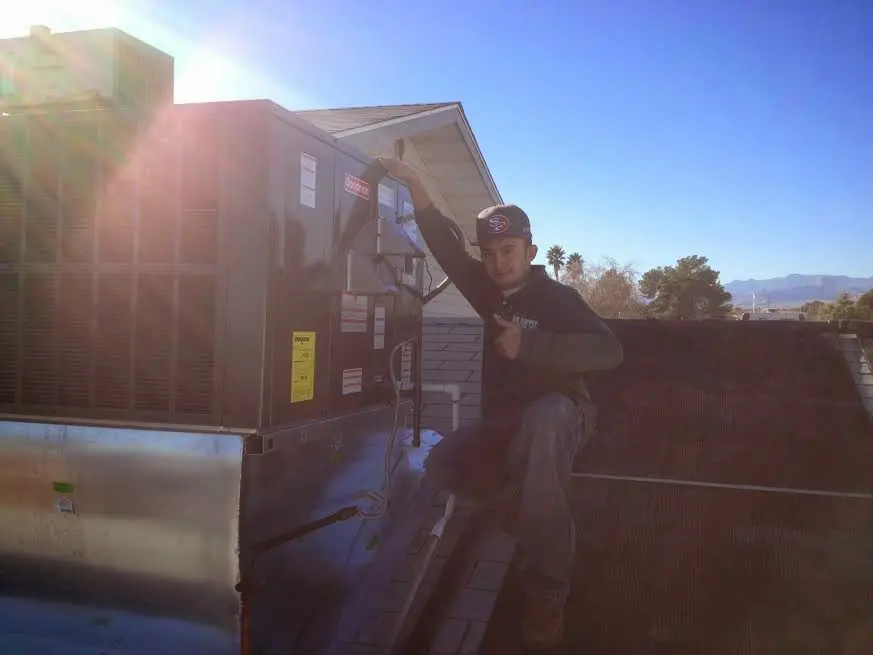 HVAC technician performing Boiler Repair on a rooftop unit in Rindge